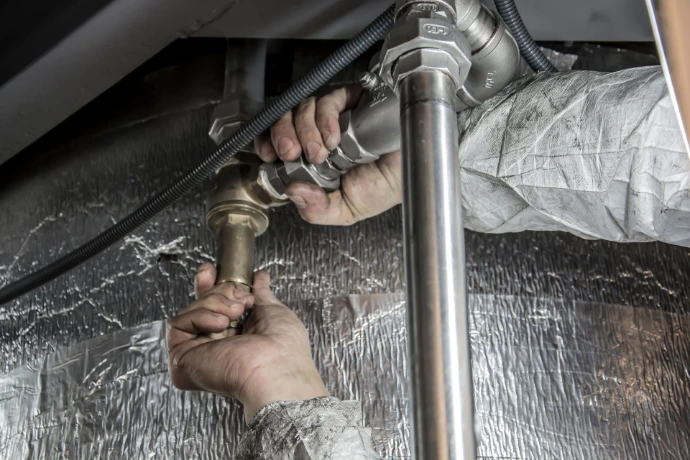 Technicien réalisant le raccordement d’une pompe à chaleur géothermique